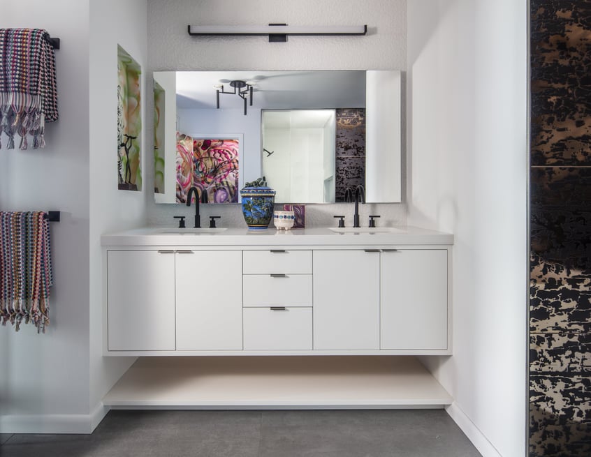 A double sink in a bathroom with modern black and white cabinets and faucets- designed by Jasmin Reese, Chicago.