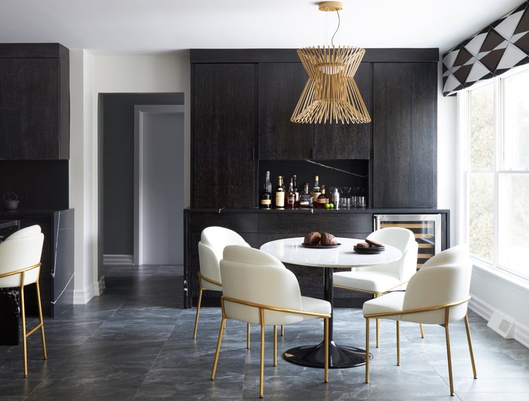 A dining room designed by Jasmin Reese with a white dinette beside a black bar cabinet, Chicago. 