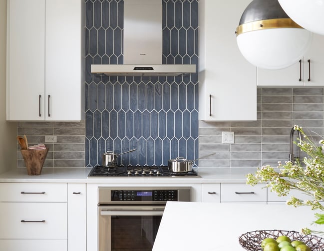 A kitchen designed by Jasmin Reese with white cabinets and cornflower blue tile backsplash, Chicago. 