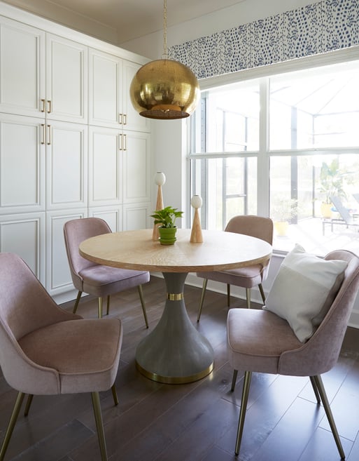 A dining room designed by Jasmin Reese with mauve dinette chairs and large globe chandelier, Chicago. 