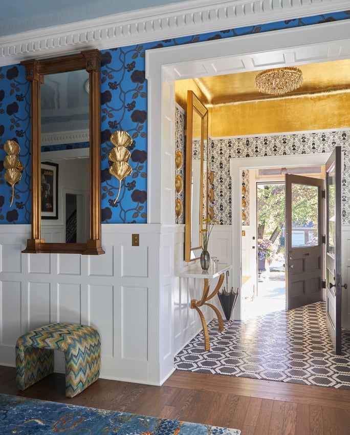 An entry hall as seen from the living room area with gold accents and a geometric pattern in black and white tile - designed by Jasmin Reese Interiors, Chicago, USA. 