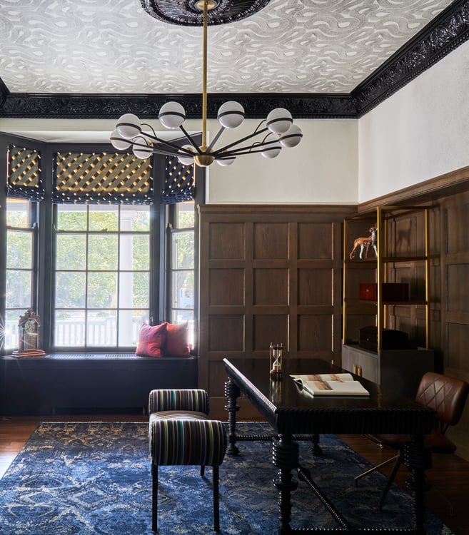  A large study with a delicate dark wood desk and settee designed by Jasmin Reese: window seat, blue rug, Chicago, USA. 