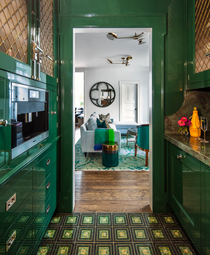 A view of a living room as seen through a bright green kitchen designed by Jasmin Reese, Chicago. 
