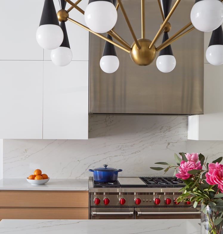 A modern kitchen design by Jasmin Reese with white cabinets, stainless steel, and marble, Chicago. 