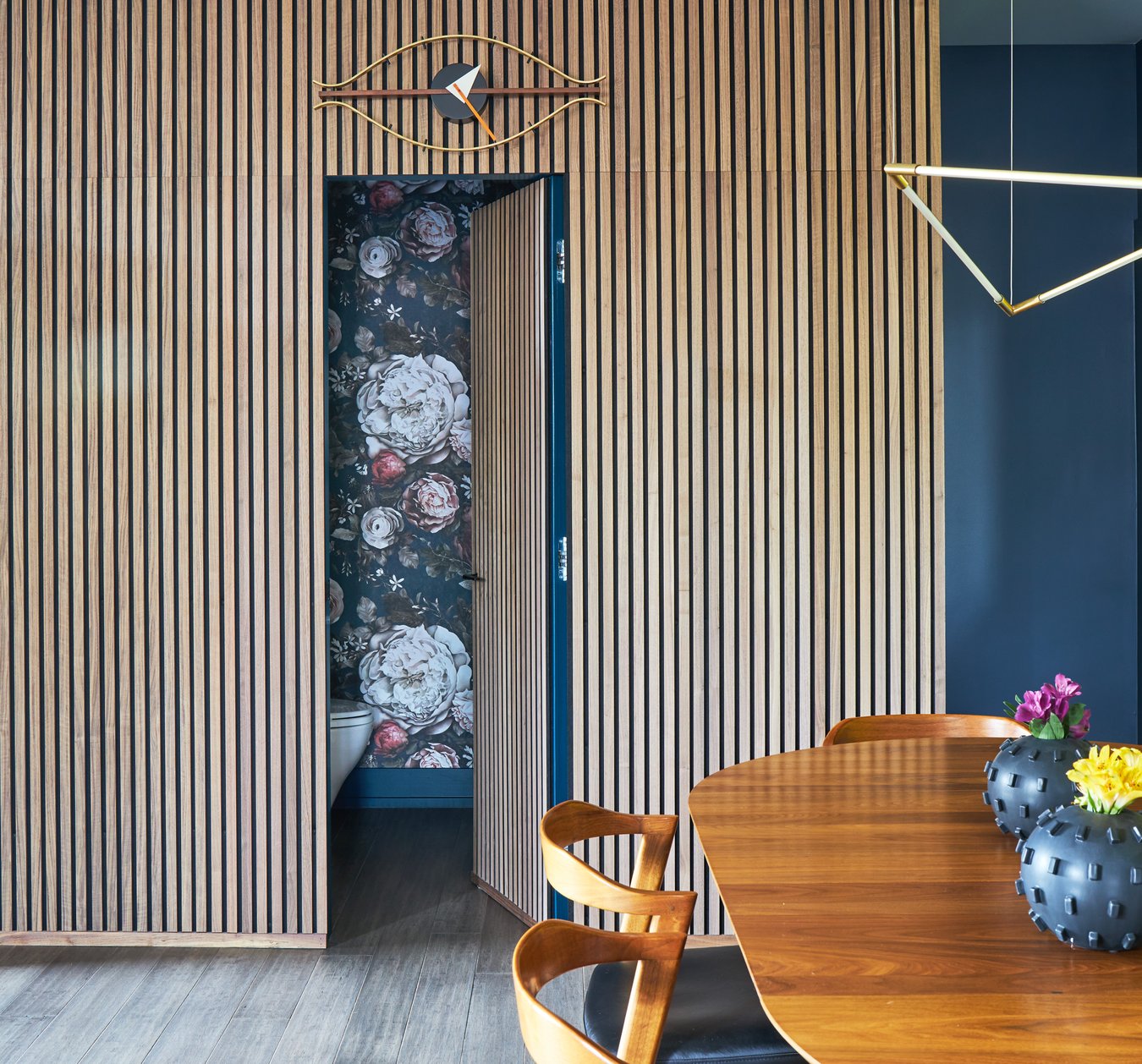 A secret door off a dining room designed by Jasmin Reese in raw wood slats, Chicago. 