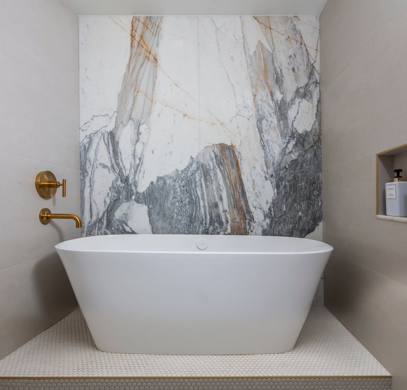 A stand-alone bathtub in a marble and tile bathroom designed by Jasmin Reese, Chicago. 