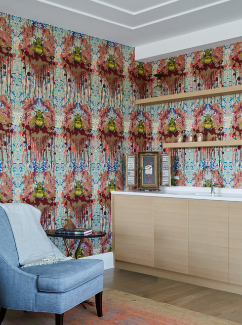 A blue chair next to a wet bar designed by Jasmin Reese, Chicago: colorful ink-blot wallpaper. 