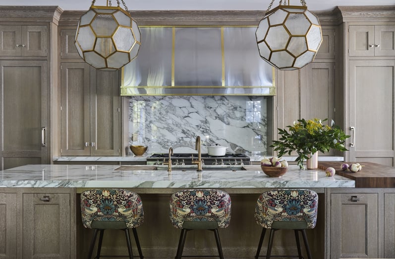 A large tradition kitchen with marble countertops with floral barstools designed by Jasmin Reese, Chicago. 