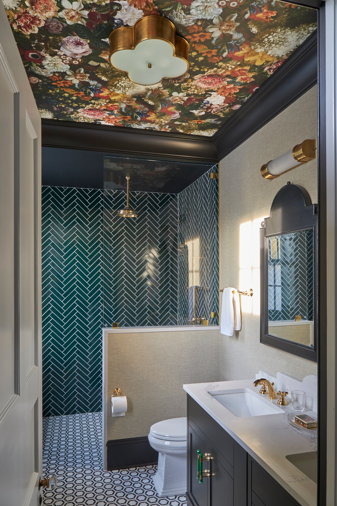 A teal and floral bathroom with subway tiles & brass fixtures in a bathroom designed by Jasmin Reese, Chicago. 