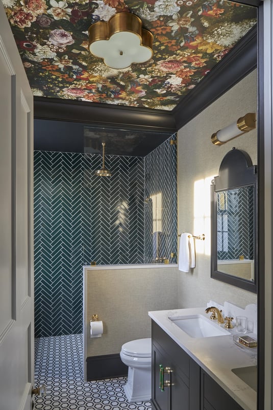 A teal bathroom with subway tiles, brass fixtures & a floral wallpaper ceiling in a bathroom designed by Jasmin Reese, Chicago. 