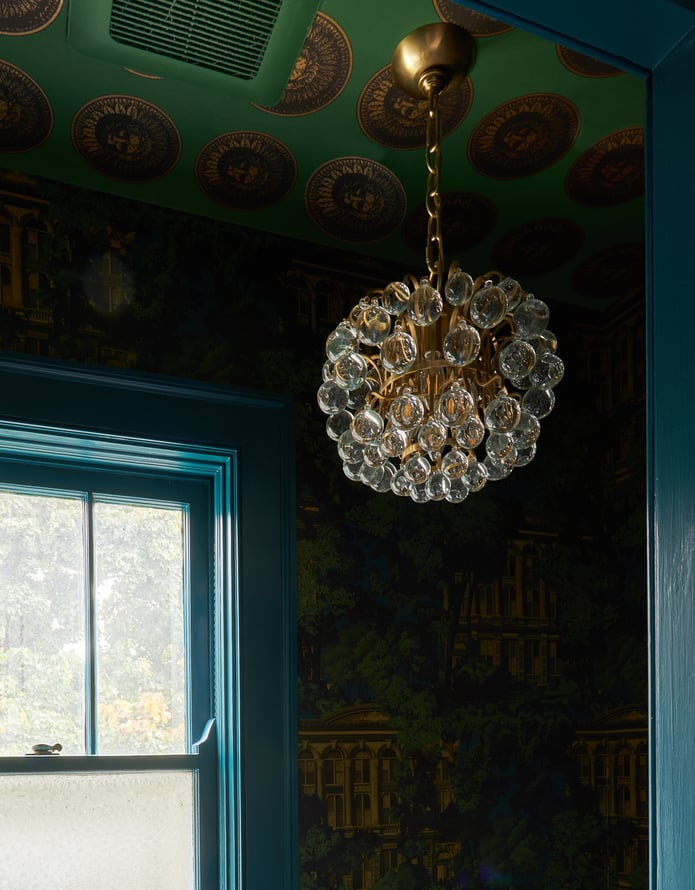 A spherical crystal and gold chandelier in a bathroom designed by Jasmin Reese, Chicago. 