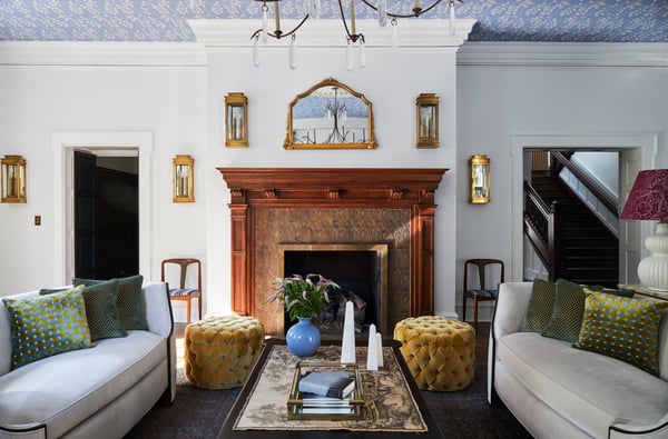 A bright white, green, and periwinkle blue living room with white sofas and an antique wooden fireplace - designed by Jasmin Reese Interiors, Chicago, USA. 