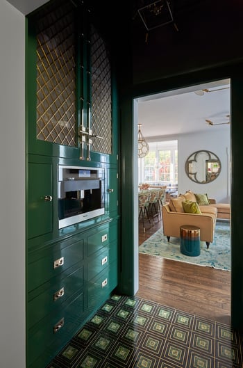 A microwave station built into green metal cabinetry in a kitchen designed by Jasmin Reese, Chicago. 