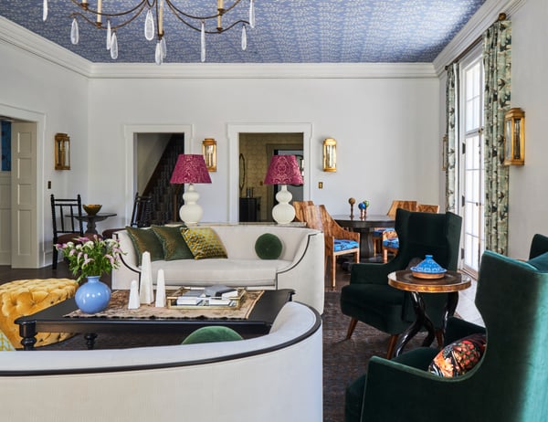 A green and white turn-of-the-century living room with two red lampshades on white modernist lamps and two forest green armchairs - living room design by Jasmin Reese Interiors, Chicago, USA. 