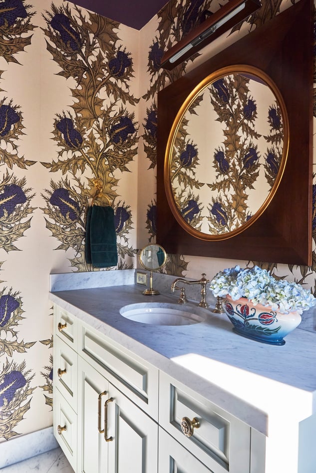 A small vanity sink in a bathroom designed by Jasmin Reese with thistle wallpaper and marble countertops, Chicago. 