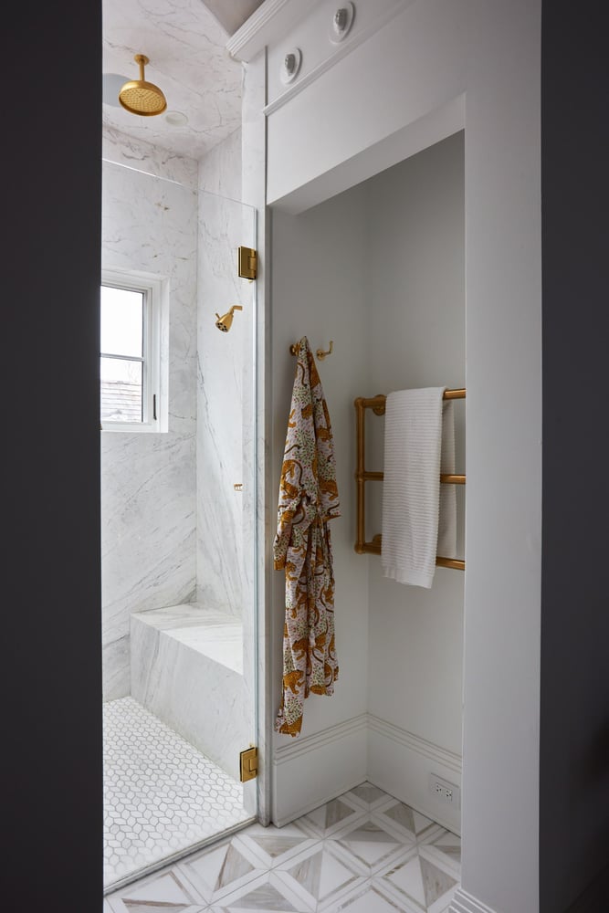  A large walk-in white tile, marble, and glass shower with copper fixtures - bathroom design by Jasmin Reese Interiors, Chicago.