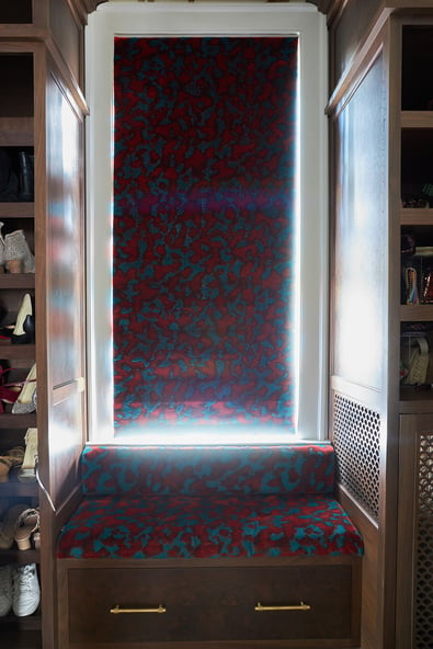 A red and turquoise window treatment in a closet with matching window seat upholstery by Jasmin Reese Interiors, Chicago. 