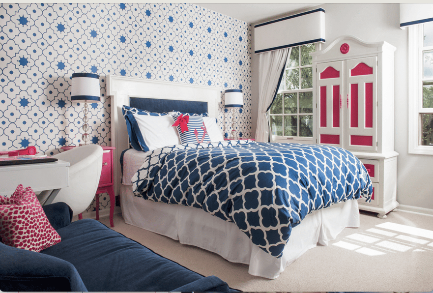 A child's bedroom designed by Jasmin Reese, Chicago: bright blue, magenta, geometric wallpaper, painted antique wardrobe. 