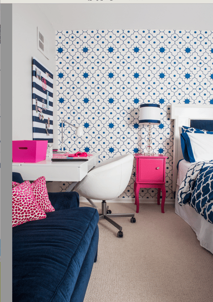 A child's desk in a bedroom designed by Jasmin Reese: bright blue sofa, hot pink bedside table, pink leopard throw pillows. 