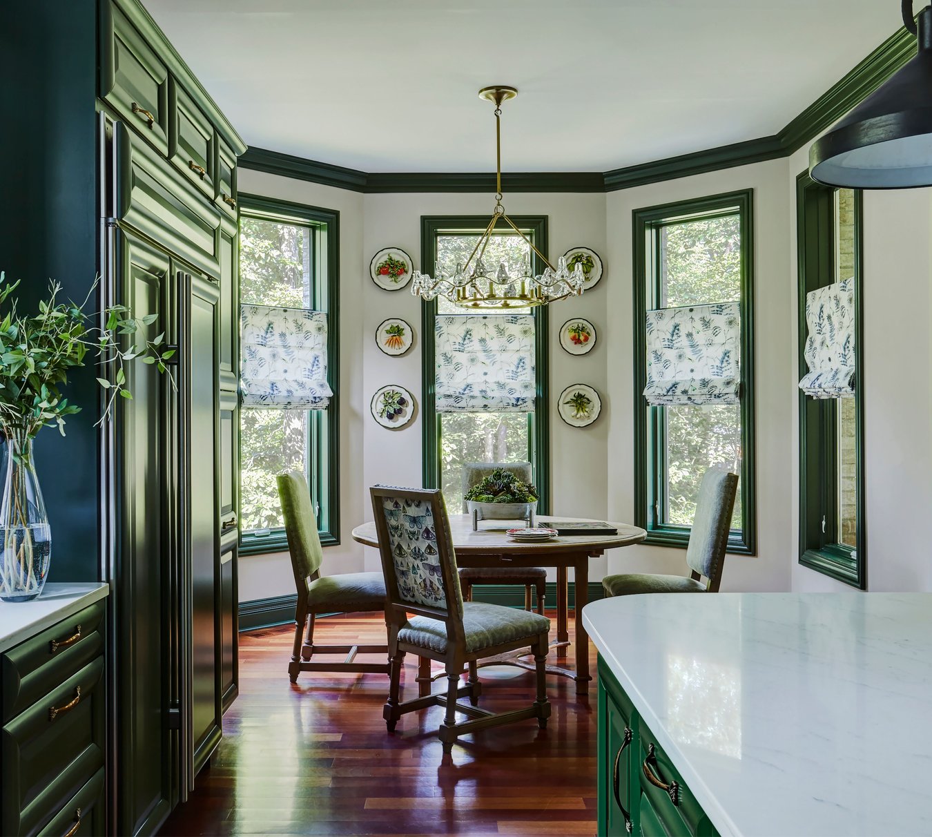 A dining room beside a kitchen designed by Jasmin Reese in bright green and marble, Chicago. 
