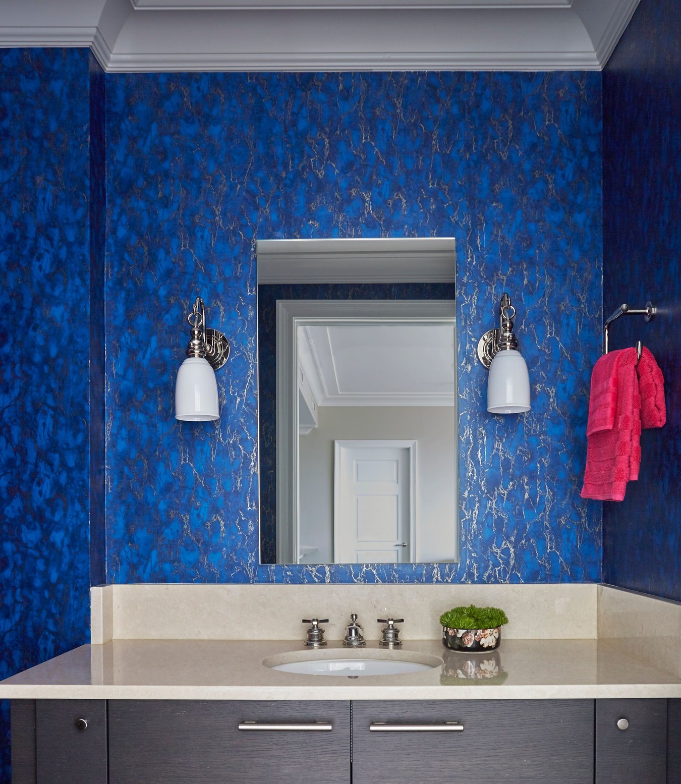 A bathroom vanity sink designed by Jasmin Reese with bright blue & silver foil wallpaper, Chicago. 