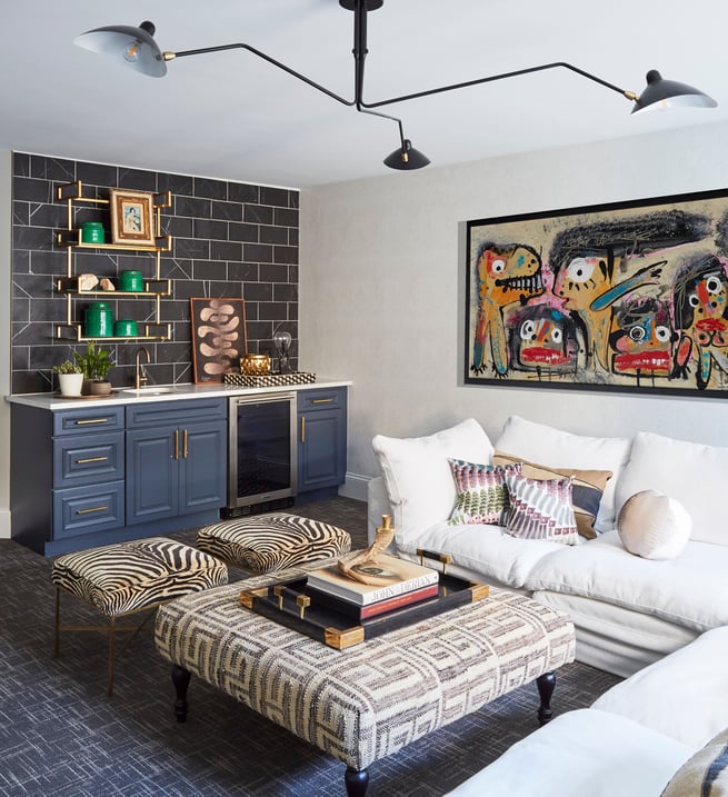 A family room designed by Jasmin Reese: white sectional sofa, wet bar, large ottoman, playful art, Chicago. 