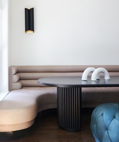 A dining room designed by Jasmin Reese with tan leather booth seating and black table, Chicago. 