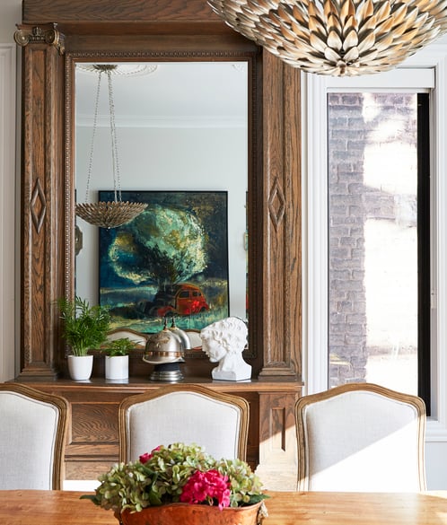 A living room design by Jasmin Reese with a large antique wooden mirror, Chicago. 