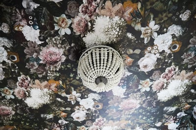A small pearl chandelier against a ceiling wallpapered with a realistic floral pattern - living room design by Jasmin Reese Interiors, Chicago, USA. 