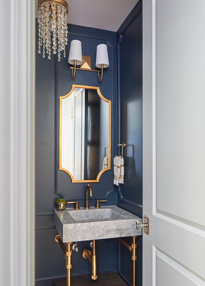 A square basin sink with rose gold fixtures in a small blue powder room designed by Jasmin Reese, Chicago. 