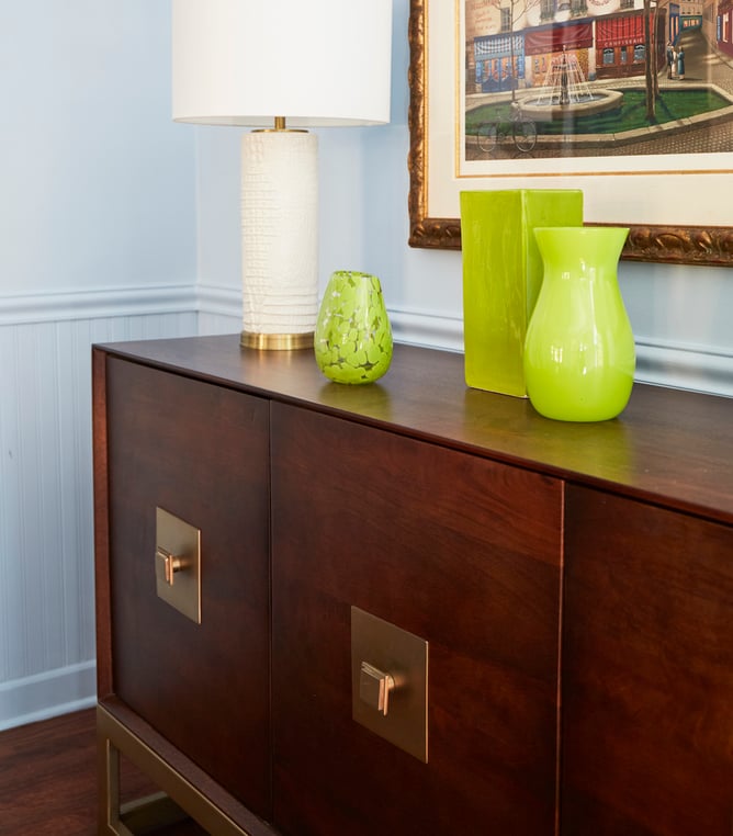 A modernist dining room design by Jasmin Reese: neon green glass vases on a modernist sideboard, Chicago. 