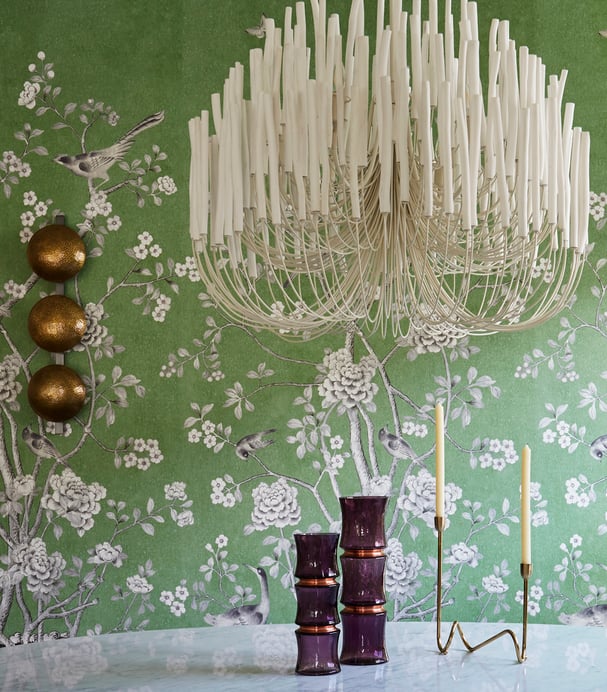 A dining room designed by Jasmin Reese with a bright, unique white candelabra and green wallpaper, Chicago. 