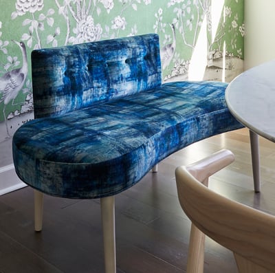 A dining room designed by Jasmin Reese with a long blue plush bench with unique design, Chicago. 