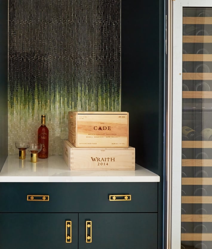 A small dry bar designed by Jasmin Reese, Chicago: tile art, marble top, unique brass fixtures, liquor boxes. 