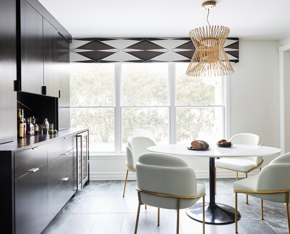 A bright white dining room designed by Jasmin Reese with black and white geometric window treatments, Chicago. 