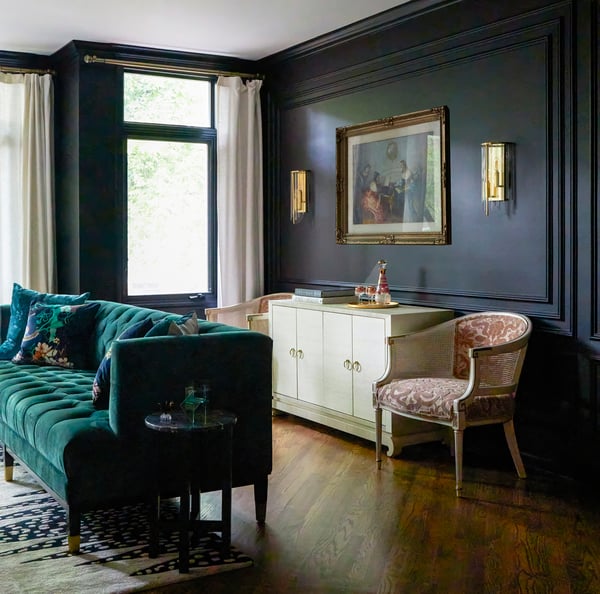 An antique bar with two circular armchairs on either side with gold framed painting against an inset wall painted black - living room design by Jasmin Reese Interior, Chicago, USA. 