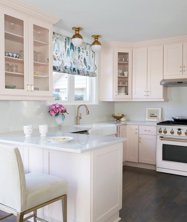 A bright traditional kitchen designed by Jasmin Reese with soft pink cabinetry and white accents, Chicago. 