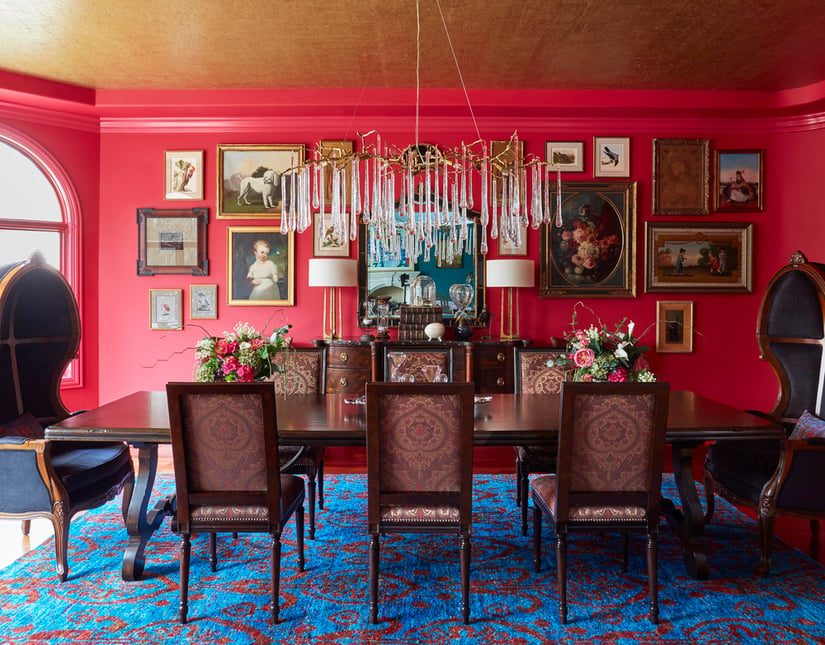 A bright red formal dining room with Victorian furniture and unique drip crystal chandelier designed by Jasmin Reese, Chicago. 