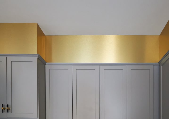 A contemporary kitchen detail of metallic gold soffit designed by Jasmin Reese Interiors, Chicago. 