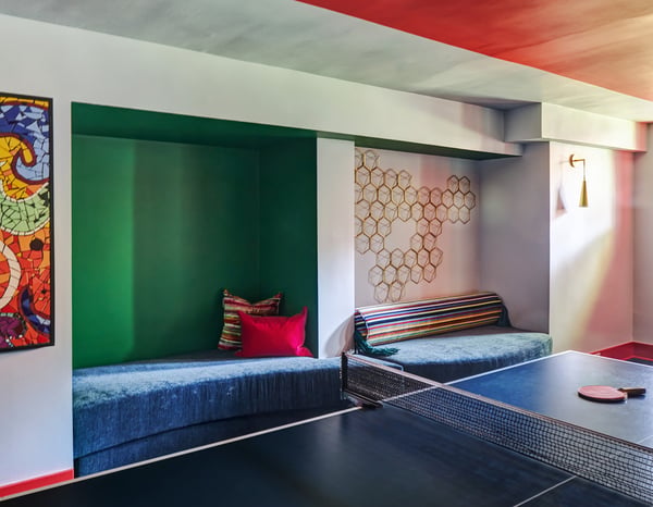 Upholstered velvet wall seating in a basement game room designed by Jasmin Reese, Chicago. 