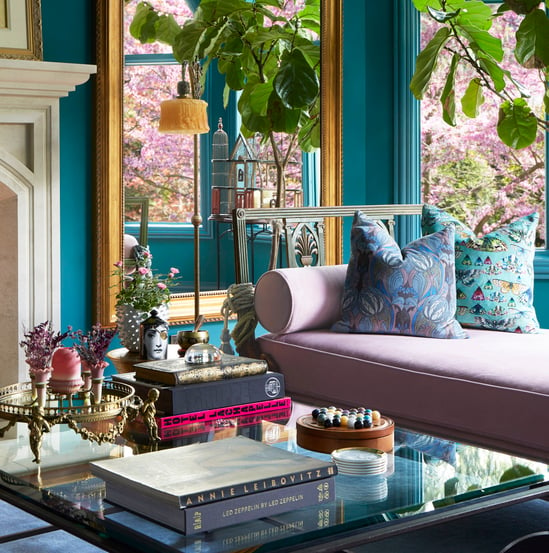 A detail on the glass coffee table in a large Moroccan-style living room with a pink velvet sofa, and turquoise walls - living room design by Jasmin Reese Interiors, Chicago, USA.