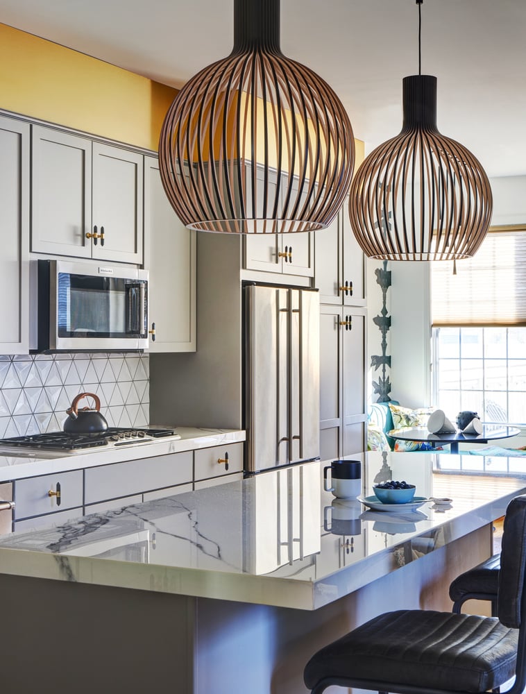 A contemporary kitchen design by Jasmin Reese with gold metallic soffit and delicate wooden drop light fixtures, Chicago. 