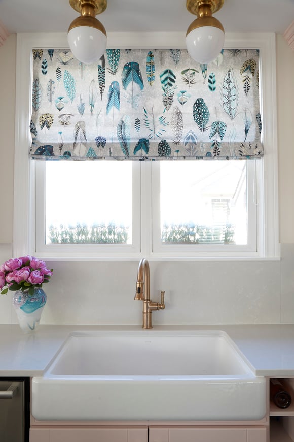 A kitchen design detail by Jasmin Reese: large marble sink, turquoise feather window treatment, rose gold faucet, Chicago. 