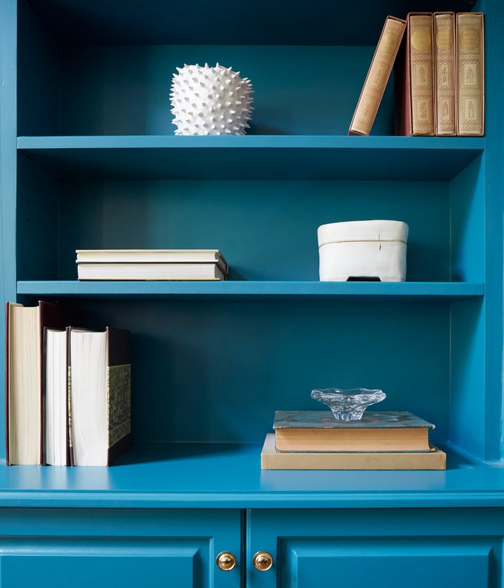 A closeup of white items on a turquoise bookshelf - living room design by Jasmin Reese Interiors, Chicago, USA. 