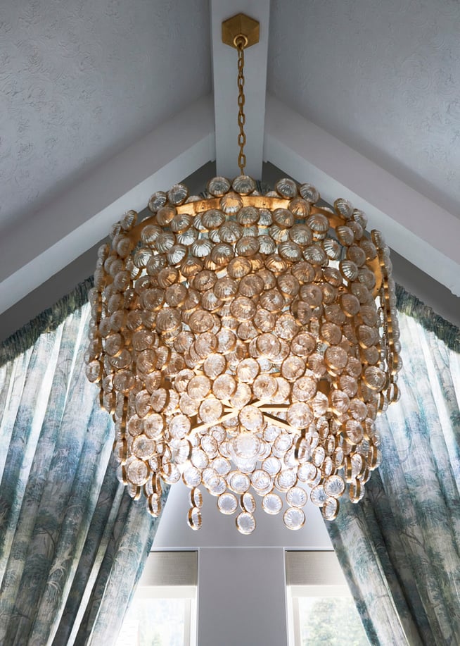 A circular crystal and pink gold chandelier in a bathroom designed by Jasmin Reese, Chicago. 