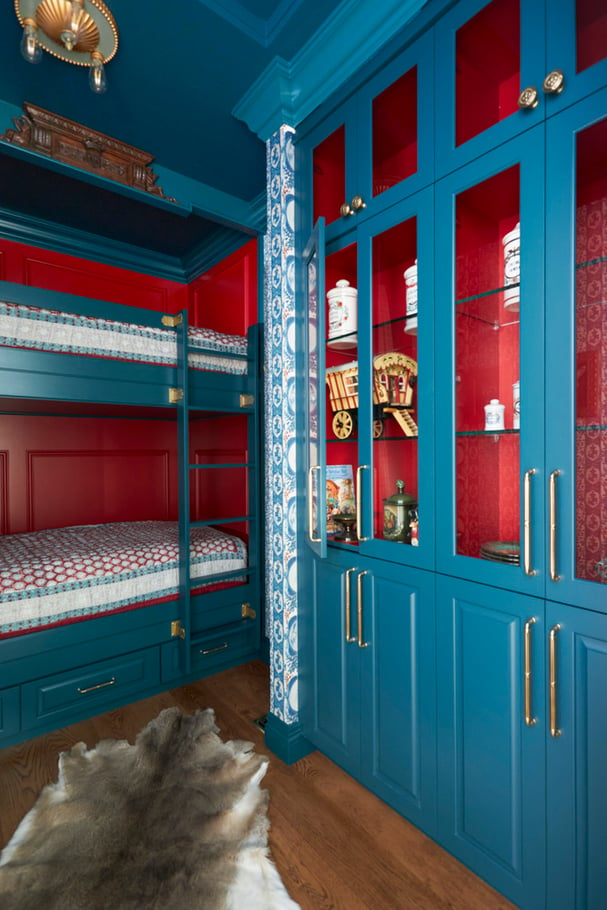 Wood and glass cabinetry in a bunk room for children designed with turquoise and red accents - interior design by Jasmin Reese Interiors, Chicago, USA.