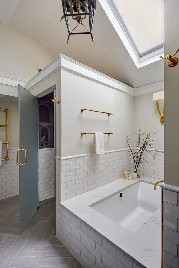 A large bathroom designed using white subway tiles and marble by Jasmin Reese, Chicago. 