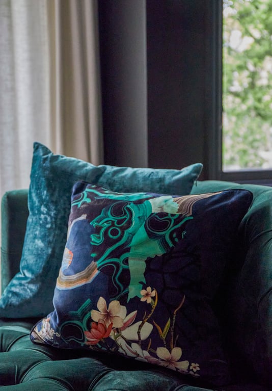 Two blue and green designer throw pillows - one with silk patches - on an emerald green sofa - living room design by Jasmin Reese Interiors, Chicago, USA. 