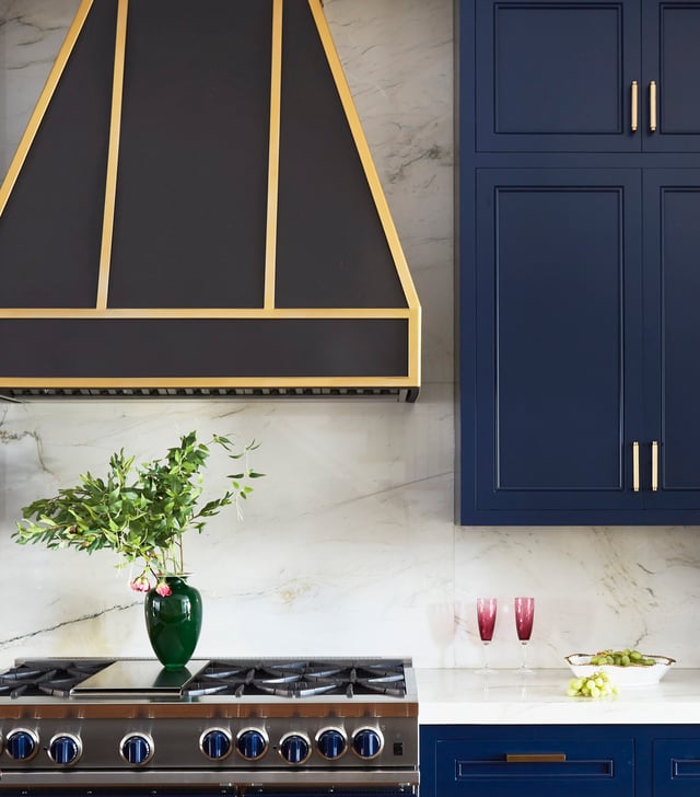 A kitchen design by Jasmin Reese with bright blue cabinetry and dark wood stove vent, Chicago. 