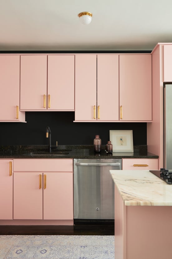 A small kitchen designed by Jasmin Reese in pink, black, and gold, Chicago. 